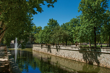 Fototapeta na wymiar View of canal at the 18th-century Gardens of the Fountain, built around the Roman thermae ruins, in the city center of Nimes. Located in the Gard department, Occitanie region in southern France