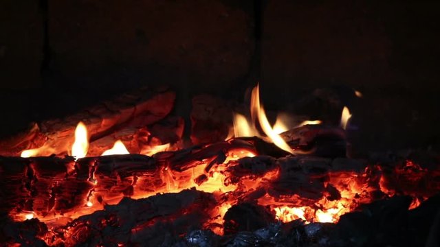 Hot coals and fire flames in fireplace, bonfire close-up.