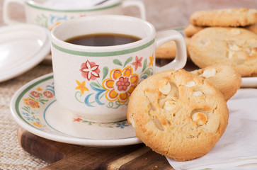 Closeup of white chocolate chip macadamia nut cookies and a cup of coffee