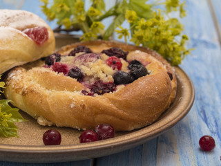 buns with berries on a blue wooden table. 