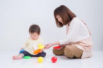 赤ちゃんと遊ぶエプロン姿の女性
