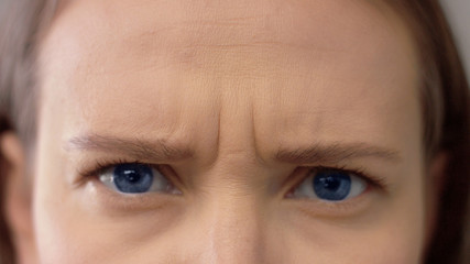 Naklejka premium eyes closeup knited her brow. blue eyed model
