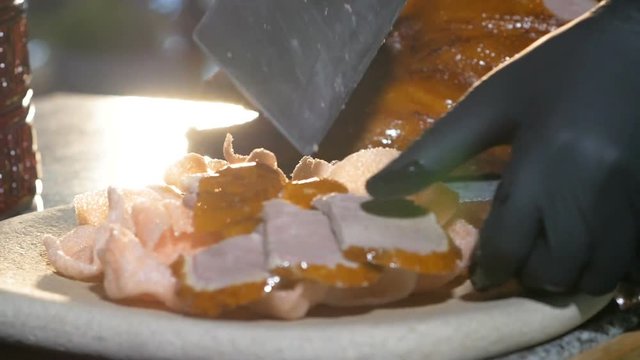 a chef slices peking duck at a restaurant
