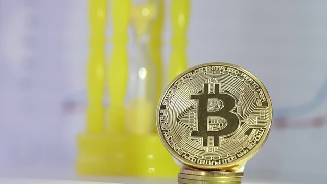 Finance investment risk concept: Bitcoin digital currency or Virtual money on blur of yellow hourglass and graph index background. Bitcoin is Digital currency modern of Exchange Virtual payment money.