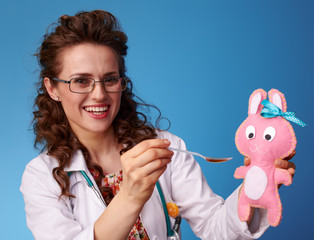 paediatrician doctor giving a spoon of children's suspension to a toy