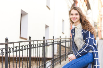 Beautiful young woman drinking coffee outside