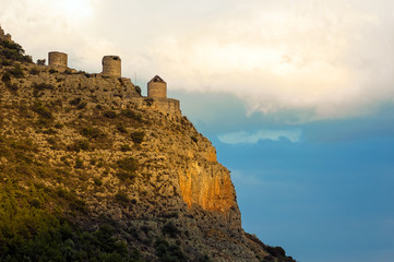 Three ruined wind mills on the famous Red Rock over the city of Leonidio in Peloponnese, Greece