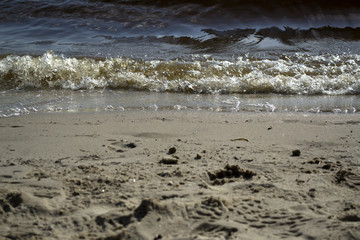 Wet sand and soft waves on a beach.