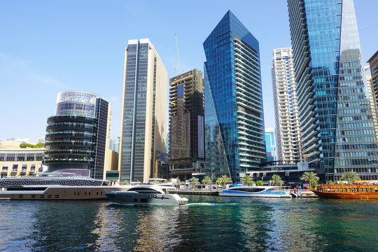 Dubai Marina with luxury skyscrapers and yachts on water pier, UAE
