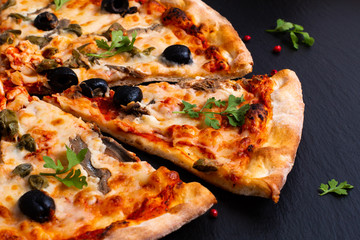 Homemade Napoli Pizza or anchovies pizza on black slate stone