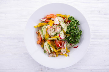 The spring vegetable fresh vegetables salad seasoned with sunflower oil with greens