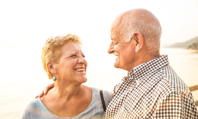 Happy senior retired couple having fun outdoors at travel vacation - Love concept of joyful elderly...