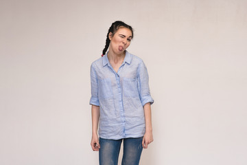 Portrait of a beautiful brunette girl on a gray background showing emotions