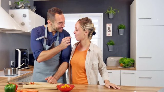 happy cheerful young couple cooking organic vegetables together at home