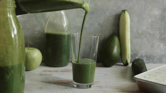 Pouring green smoothies in a glass, made with zucchini banana, celery and broccoli  smoothie, detox concept , healthy lifestyle.