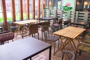 chairs and wooden tables in indoor industrial and modern style canteen - empty with nobody using the area