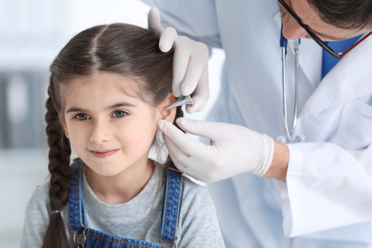 Children's doctor examining little girl in hospital