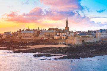 Beautiful view of walled city Saint-Malo with St Vincent Cathedral at sunrise at high tide. Saint-Maol is famous port city of Privateers is known as city corsaire, Brittany, France - obrazy, fototapety, plakaty