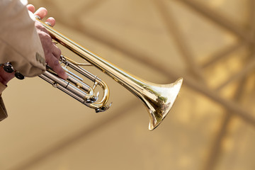 Naklejka na ściany i meble Closeup of a hand of a European musician playing on a trumpet.