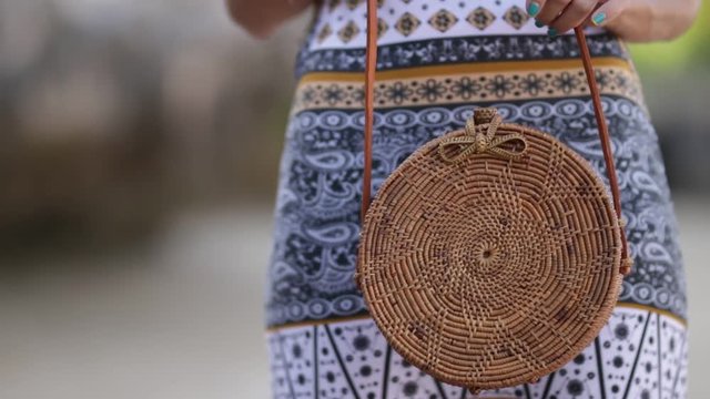 Woman with fashionable stylish rattan bag on the beach. Tropical island of Bali. Handmade Rattan eco handbag HD footage.