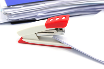 Pink stapler and paper document on white background, Office equipment.