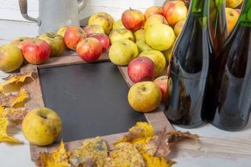 chalkboard with organic fresh apples and bottles of Normandy cider