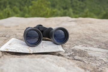 binoculars on the map. Lies on the top of the mountain, tourism travel, navigation, gps, orientation on the terrain, trekking.