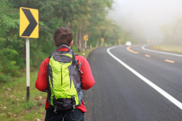 Young girl backpack walking on the road trip in the winter.