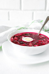 Traditional cold soup with okroshka of beetroot, cucumber and spring onion spring vegetarian dish super food on light background with copy space in rustic style