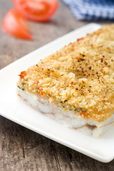White fish casserole with cheese on wooden background.