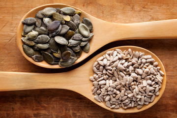 Semi di girasole e semi di zucca nei cucchiai di legno.