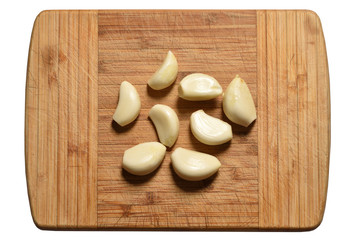 Fresh and peeled garlic is on the cutting board. close-up