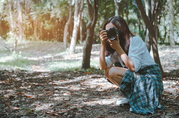 photographer girl using camera take a photo in forest at holiday. attractive woman adventure hiker go to trekking in the forest sightseeing natural at holiday travel concept.