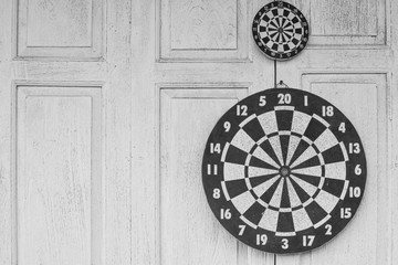 The darts board on white wooden background.
