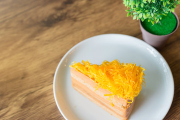 Thai tea layer cake on white plate.