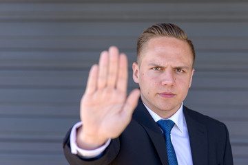 Young businessman giving a halt gesture