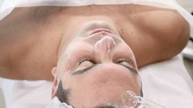 Darsonvalization. Man having darsonval therapy. Facial skin care in beauty saloon. electric darsonval massage procedure