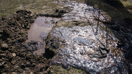 Background texture of an oil spill on the surface of the soil . Environmental pollution.