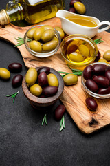 black and green olives and oil on wooden cutting board
