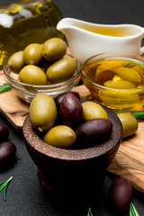 black and green olives and oil on wooden cutting board