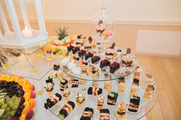 Delicious sweets on wedding candy buffet with desserts, cupcakes