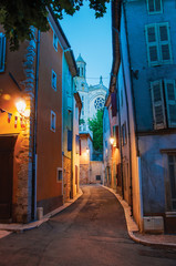 View of narrow alley and church in the early evening with lamp lit, in the lovely village of Rians. Located in Var department, Provence region, in southeastern France.