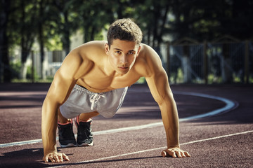 Obraz premium Attractive fitness man doing exercises in park