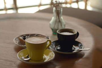 Cup of coffee and blueberry cheese pie on table in cafe