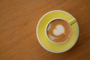 Cup of cappuccino coffee on table in cafe