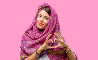 Young arab woman wearing hijab happy showing love with hands in heart shape expressing healthy and marriage symbol