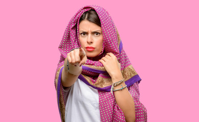 Young arab woman wearing hijab pointing to the front with finger