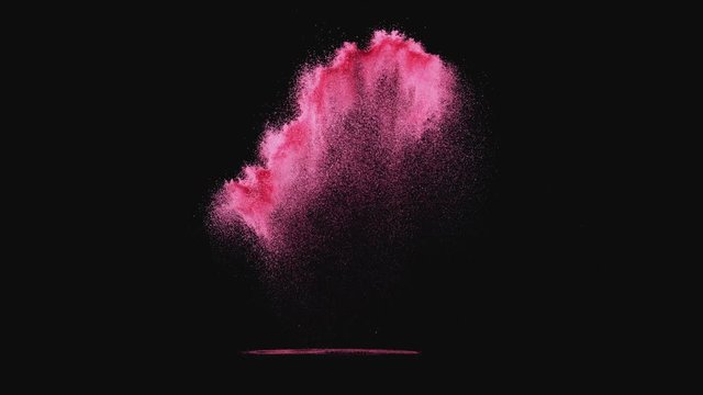 Colored powder/particles fly against black background. Shot with high speed camera, phantom flex 4K. Slow Motion.