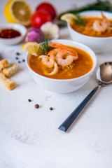Lentil soup with seafood. Red soup with shrimps and squid