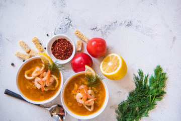 Lentil soup with seafood. Red soup with shrimps and squid